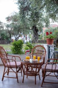 - une table et des chaises avec du jus d'orange sur la terrasse dans l'établissement Villa Rita & Helena, à Kalámi