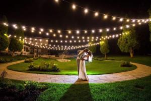 a bride and groom dancing in the garden at night at StoneHaven Le Manoir - Relais & Châteaux in Sainte-Agathe-des-Monts