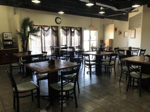 a restaurant with tables and chairs and a clock on the wall at The Grand Inn Peoria in Peoria