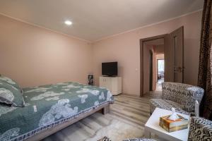 una camera con letto, sedia e televisore di Nice&Cozy Apartament a Sighişoara