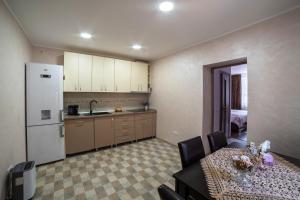 una cucina con tavolo e frigorifero bianco di Nice&Cozy Apartament a Sighişoara