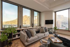 a living room with a couch and large windows at #1803 Cartwright - Simply Spectacular in Cape Town