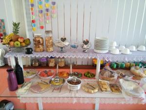 a table with many different types of food on it at Pousada Lilás in Angra dos Reis