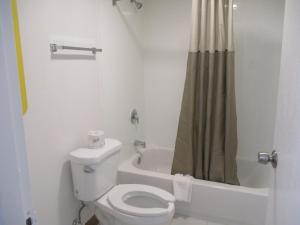 a white bathroom with a toilet and a shower at Motel 6 Chattanooga - Airport in Chattanooga +58 photos