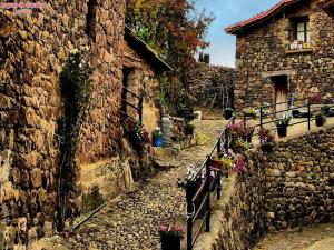 an old stone alley with a stone building at Hotel Rural Camero Viejo in Laguna de Cameros