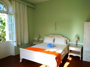 a bedroom with a white bed with an orange blanket at Romantic rooms with stunning sea view in Rhodes Town +36 photos
