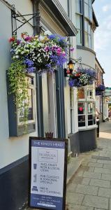 a sign in front of a building with flowers at Kings Head Holt in Holt