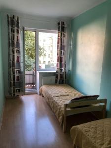 Vanalinna Apartment في تالين: غرفة نوم بسريرين ونافذة كبيرة