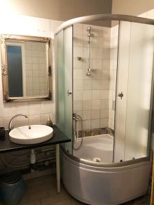 ein Bad mit einer Badewanne, einem Waschbecken und einer Dusche in der Unterkunft Vanalinna Apartment in Tallinn