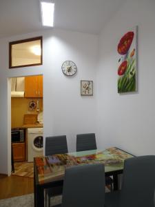 un comedor con una mesa y un reloj en la pared en Charming apartment in the heart of the town, en Veliko Tŭrnovo