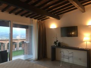 a bedroom with a bed and a tv and a window at Il Poggio in Ascoli Piceno