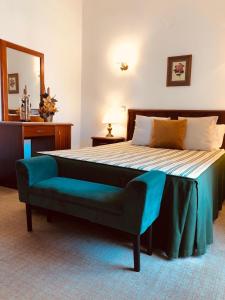 a bedroom with a large bed with a blue bench at Hospedaria S. Jorge in Fátima