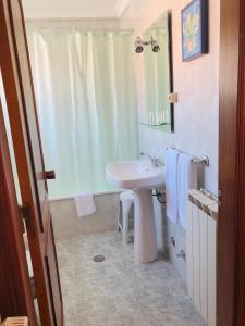 uma casa de banho branca com um lavatório e um espelho em Hospedaria S. Jorge em Fátima