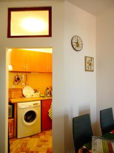cocina con lavadora y reloj en la pared en Charming apartment in the heart of the town, en Veliko Tŭrnovo