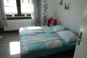 una camera da letto con un letto con un piumone blu e una finestra di Ferienhaus Rurperle a Nideggen