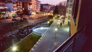 una calle de la ciudad por la noche con un río y edificios en "При братята" - Apartments & Studios en Sandanski