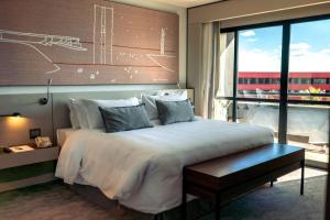 una camera con un grande letto e una grande finestra di Royal Tulip Brasília Alvorada a Brasilia