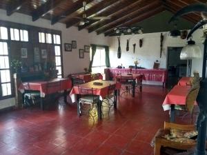 a restaurant with red tables and chairs in a room at Hostería Niemanu in Paso de la Patria