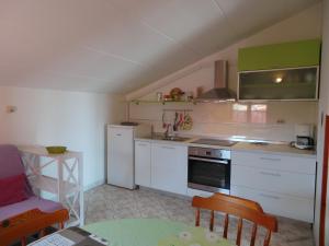 a kitchen with white cabinets and a stove top oven at Apartment Fazana 11 in Štinjan