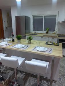 eine Küche mit einem Tisch mit Tellern und Weingläsern in der Unterkunft Piso muy amplio Casco Historico in Cartagena