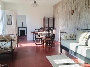 a living room with a bed and a table and chairs at Maison de ville jardin 2km de Tours in Saint-Pierre-des-Corps