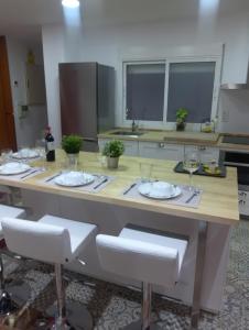 eine Küche mit einem Tisch mit Stühlen und Weingläsern in der Unterkunft Piso muy amplio Casco Historico in Cartagena + 32 Fotos