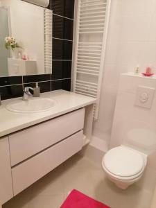 a white bathroom with a toilet and a sink at Lanterna Apartment in Zagreb