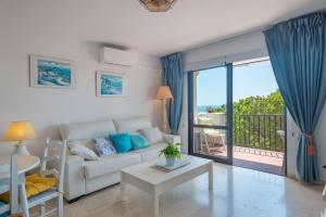a living room with a couch and a balcony at Beach Apartment Las Acacias Torrenueva in La Cala de Mijas