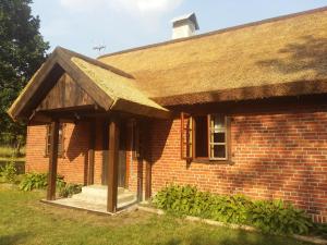 una casa in mattoni con tetto di paglia di Dom Letniskowy Wakacje Pod Strzechą a Markocin