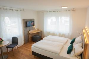 1 dormitorio con cama, escritorio y silla en SP-Appartements, en Neuhausen auf den Fildern