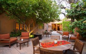 a patio with tables and chairs and a tree at Inn on the Alameda in Santa Fe