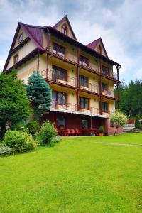 a large building with a lawn in front of it at Agroturystyka U Misia in Niedźwiedź