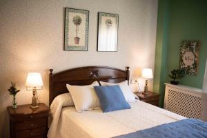 a bedroom with a bed with two night stands and two lamps at APARTAMENTO FRANCISCO PIZARRO in Trujillo