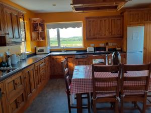 uma cozinha com armários de madeira e uma mesa com uma toalha de mesa em Ballyallaght House em Bushmills