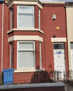 una casa de ladrillo rojo con puerta blanca en Bright, Comfortable Home, Convenient for City Centre, en Liverpool