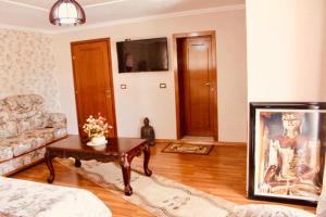 ein Wohnzimmer mit einem Sofa und einem Tisch in der Unterkunft Guest House Stena in Ersekë