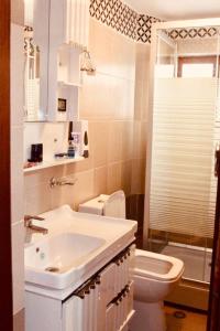 a white bathroom with a sink and a toilet at Guest House Stena in Ersekë