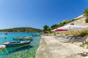 eine Gruppe von Booten im Wasser neben einem Strand in der Unterkunft Apartments Otjana in Sevid