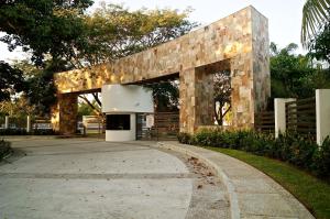 un bâtiment en pierre avec une passerelle dans un parc dans l'établissement Penthouse con Jacuzzi en Acapulco Diamante, à Acapulco