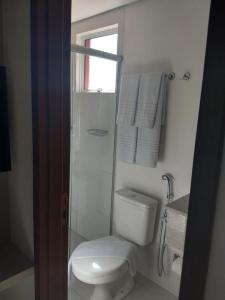 a bathroom with a toilet and a shower and towels at EVIAN THERMAS RESIDENCE in Caldas Novas