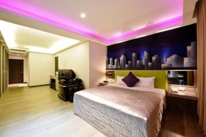 a bedroom with a bed with a purple lighting at Carnival Motel in Taipei