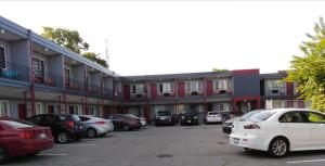 un parking avec des voitures garées devant un bâtiment dans l'établissement Sunrise Inn, à Niagara Falls