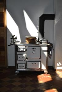 an old stove in a room with a shadow on the floor at Maison Pittoresque in Hermerswiller