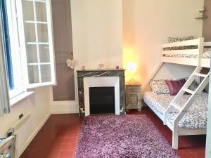 ein Schlafzimmer mit einem Etagenbett und einem Kamin in der Unterkunft Maison de ville jardin 2km de Tours in Saint-Pierre-des-Corps