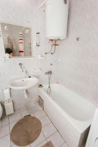 a bathroom with a sink and a tub and a toilet at Ovcina Garden view residence in Sarajevo