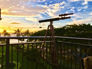 a camera on a balcony with the sunset in the background at Beach Villa at Ko'Olina in Kapolei