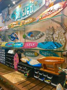 un affichage en magasin avec des planches de surf et des plaques sur une étagère dans l'établissement Beach Villa at Ko'Olina, à Kapolei