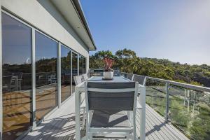 a table and chairs on the balcony of a house at The Cove Bay of Fires in Binalong Bay