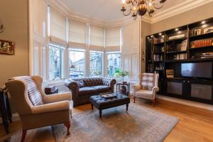 uma sala de estar com cadeiras, uma televisão e um sofá em Beautiful Property In A Fantastic Location em St. Andrews