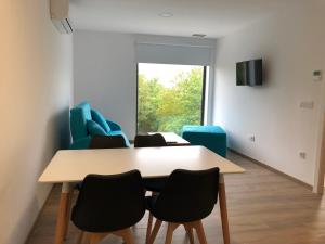 a dining room with a table and chairs and a window at Apartamentos Compostela in Lobios
